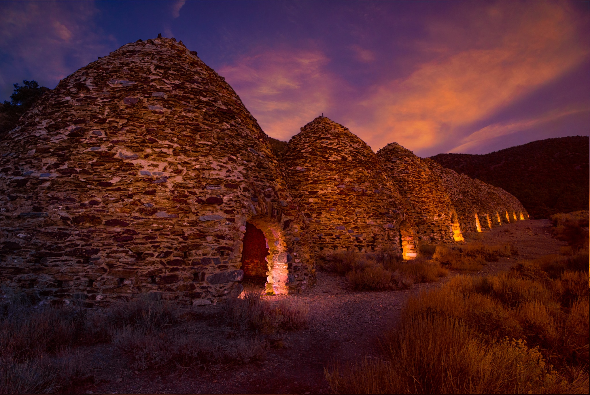 After sunset, lights illuminate the openings of the ten charcoal kilns located at the end of Wildrose Canyon in Death Valley National Park, California.