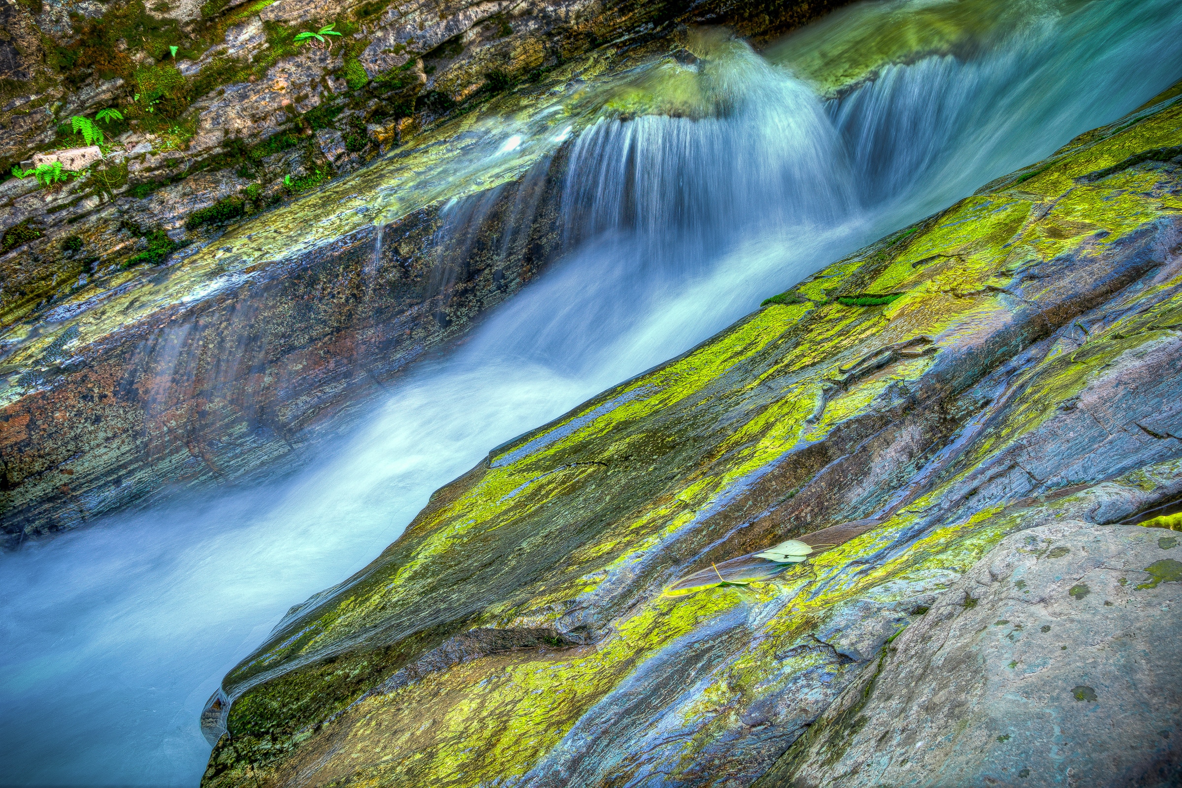 Water splashes along the cascade flowing through Sunrift Gorge in Glacier National Park, Montana.