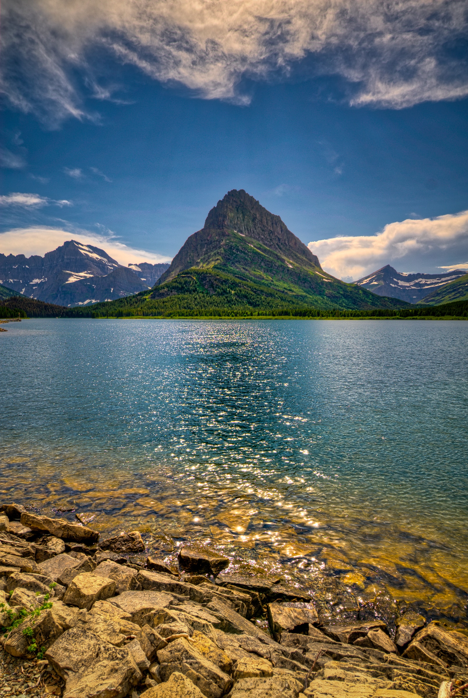 Afternoon sunlight sparkles on Swiftcurrent Lake with Mt. Grinnell in the background in Glacier National Park, Montana.
