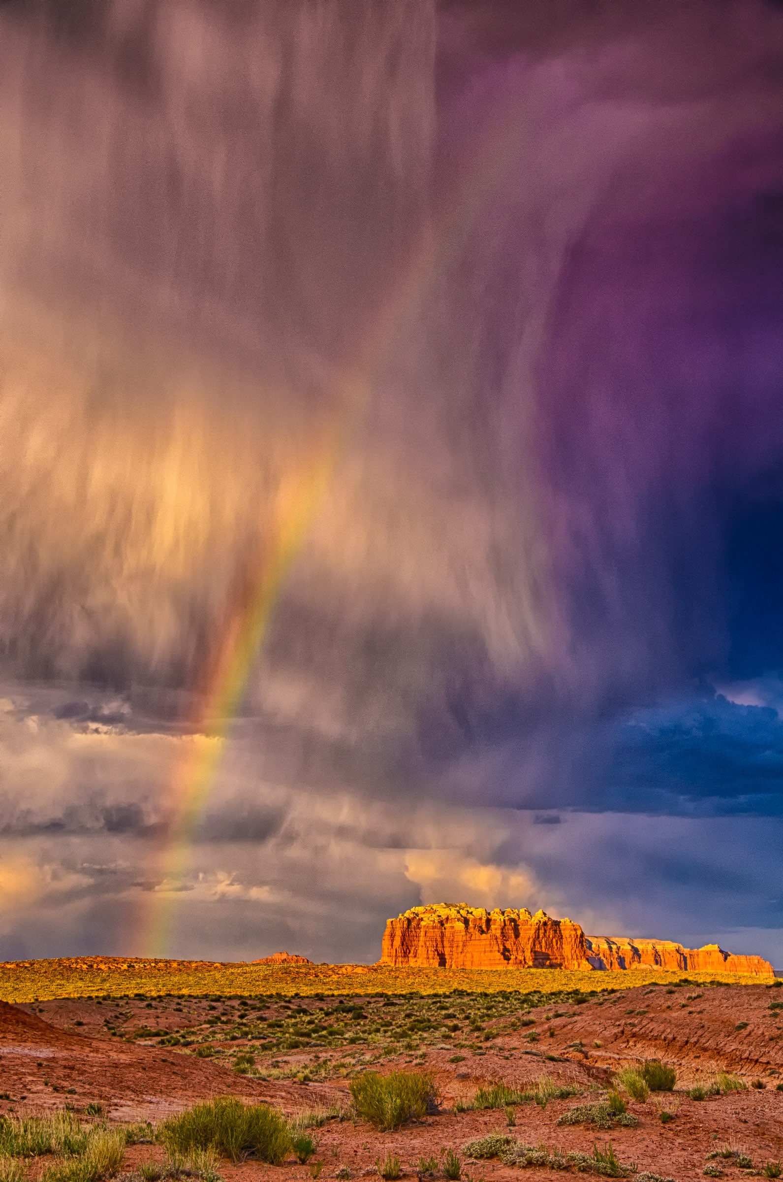 The virga from a passing thunderstorm doesn't touch the ground, but the rainbow seems to, in Goblin Valley Sate Park near Hanksville, Utah.