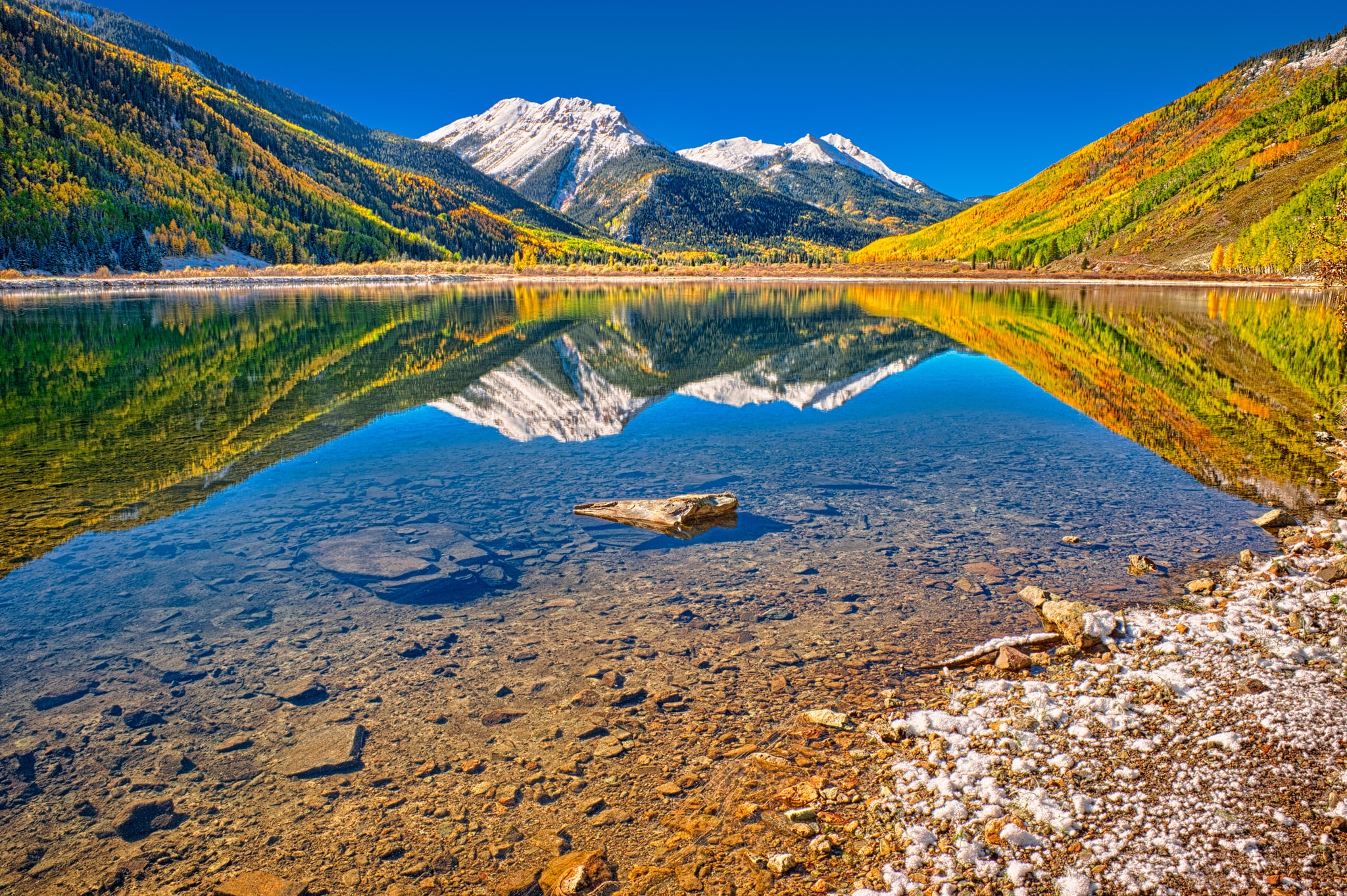 Snowy Red Mountain and autumn aspens are reflected in Crystal Lake, located on US 550 near Ironton, Colorado.