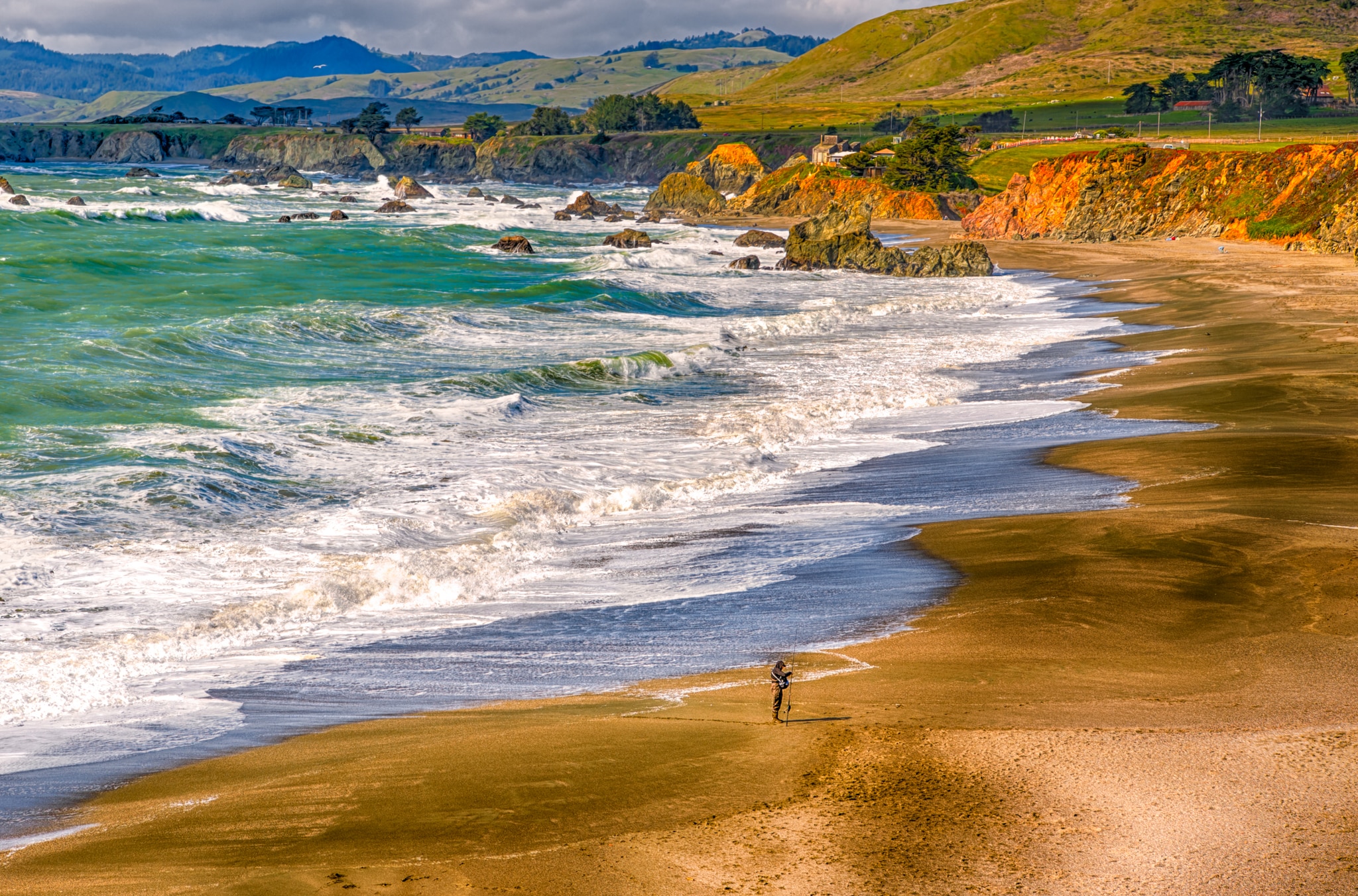 People in Nature - A fisherman enjoys an afternoon on the beach at Duncan's Landing, along CA Highway 1 in California. California's Pacific Coast
