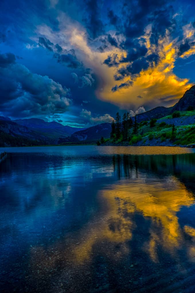The last light of sunset illuminating a cloud is reflected the the water of Lake San Cristobal near Lake City, Colorado.