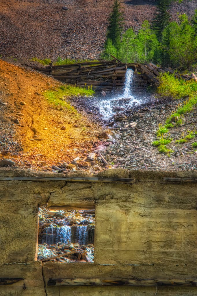 Outflow from the Old Hundred Mine creates a little cascade before emptying into Cunningham Creek, which runs along San Juan County Road 4 outside of Silverton, Colorado. Part of the Juan Mountain mining ruins collection.