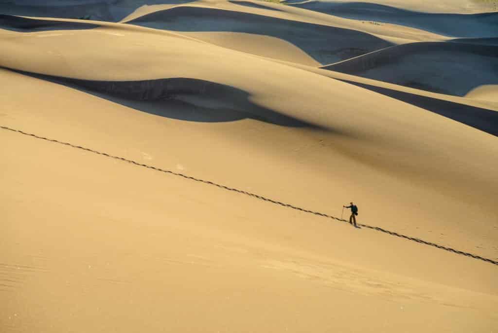 A distant hiker stops for a breather while following a trail up to the top of the first ridge of dunes in Great Sand Dunes National Park and Preserve, near Alamosa, Colorado.