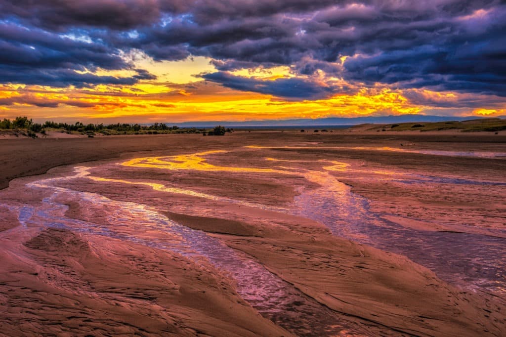 The last light of day turns the waters of Medano Creek gold in Great Sand Dunes National Park and Preserve, near Alamosa, Colorado.