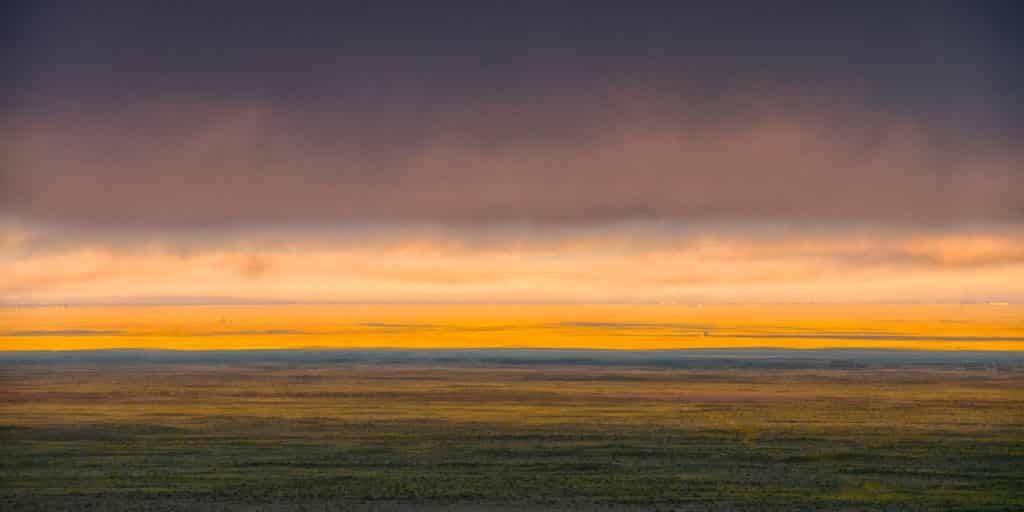 This panorama shows golden cloud cover shrouding the tops of the dunes on an early morning in September at Great Sand Dunes National Park and Preserve near Alamosa, Colorado.
