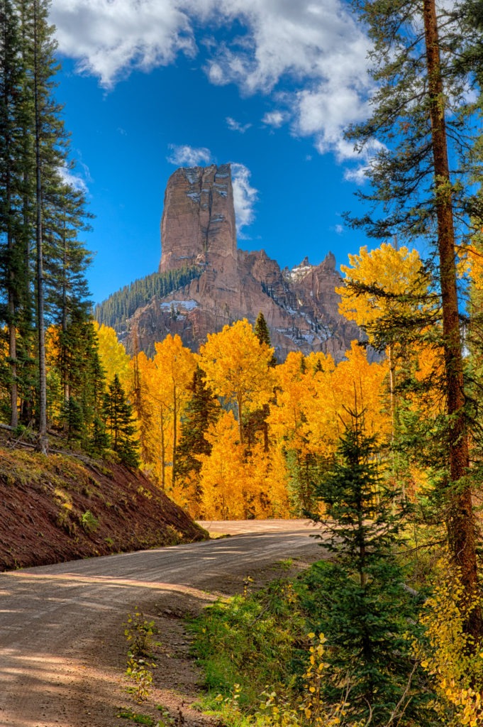 Morning light and golden aspens highlight the view of Courthouse Rock as seen from the Owl Creek Pass Road between Ridgway and Cimarron, Colorado.