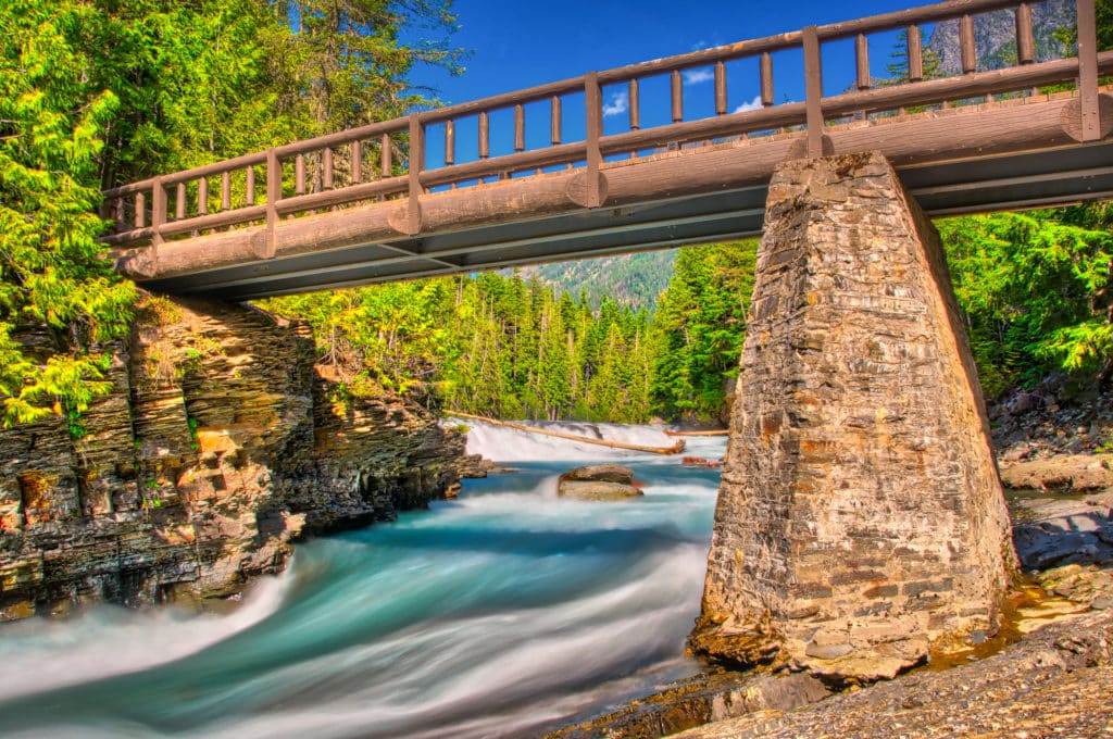 This log footbridge crosses the river between Sacred Dancing Cascades and McDonald Falls, along Going to the Sun Road in Glacier National Park, Montana.