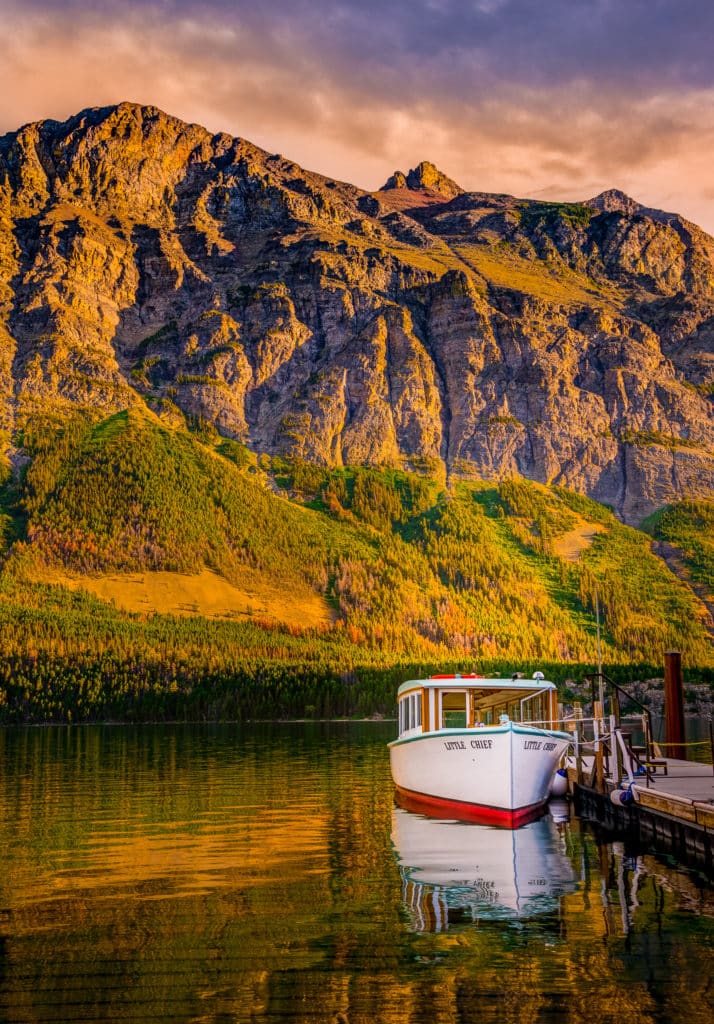 A tour boat docked to a pier on St. Mary Lake in Glacier National Park in Montana.