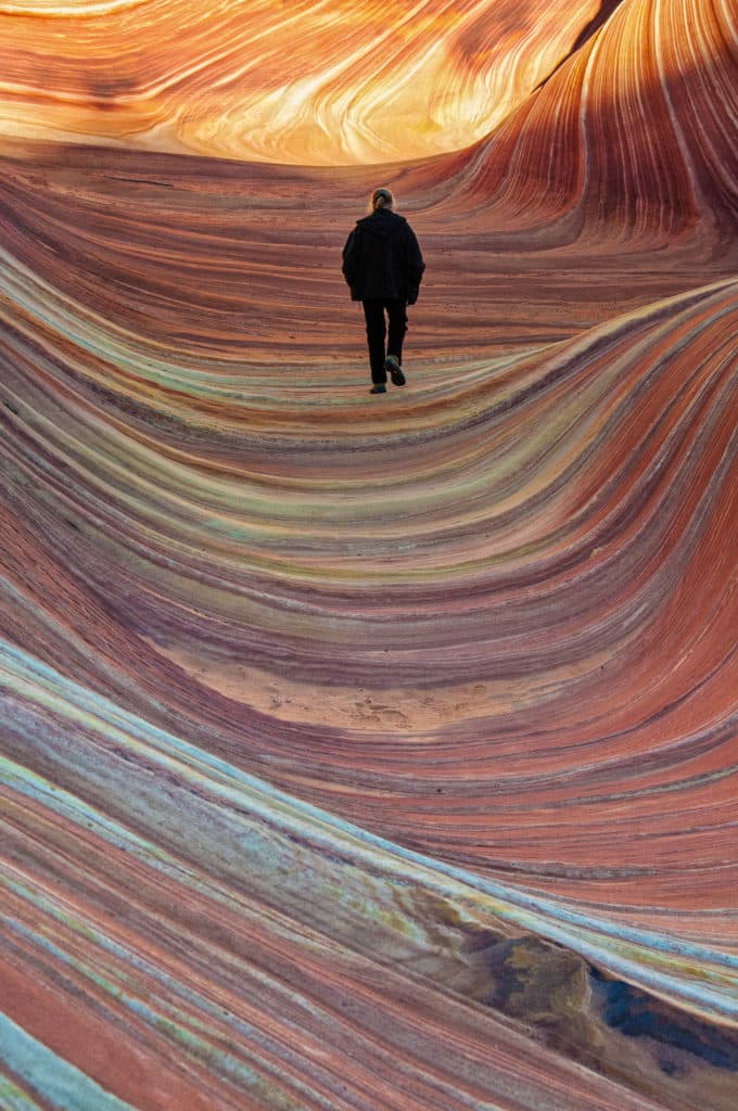 Woman walking through the Wave in the North Coyote Butte area of Vermillion CLiffs National Monument.