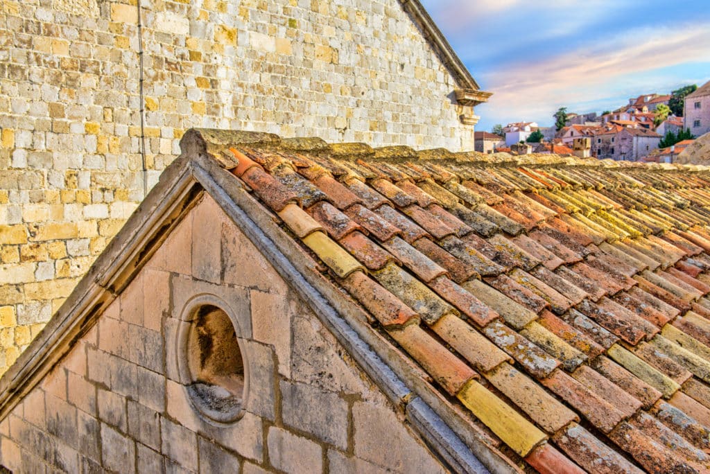 A red-tiled roof and pediment as seen from the city walls of Dubrovnik Old Town in Croatia.