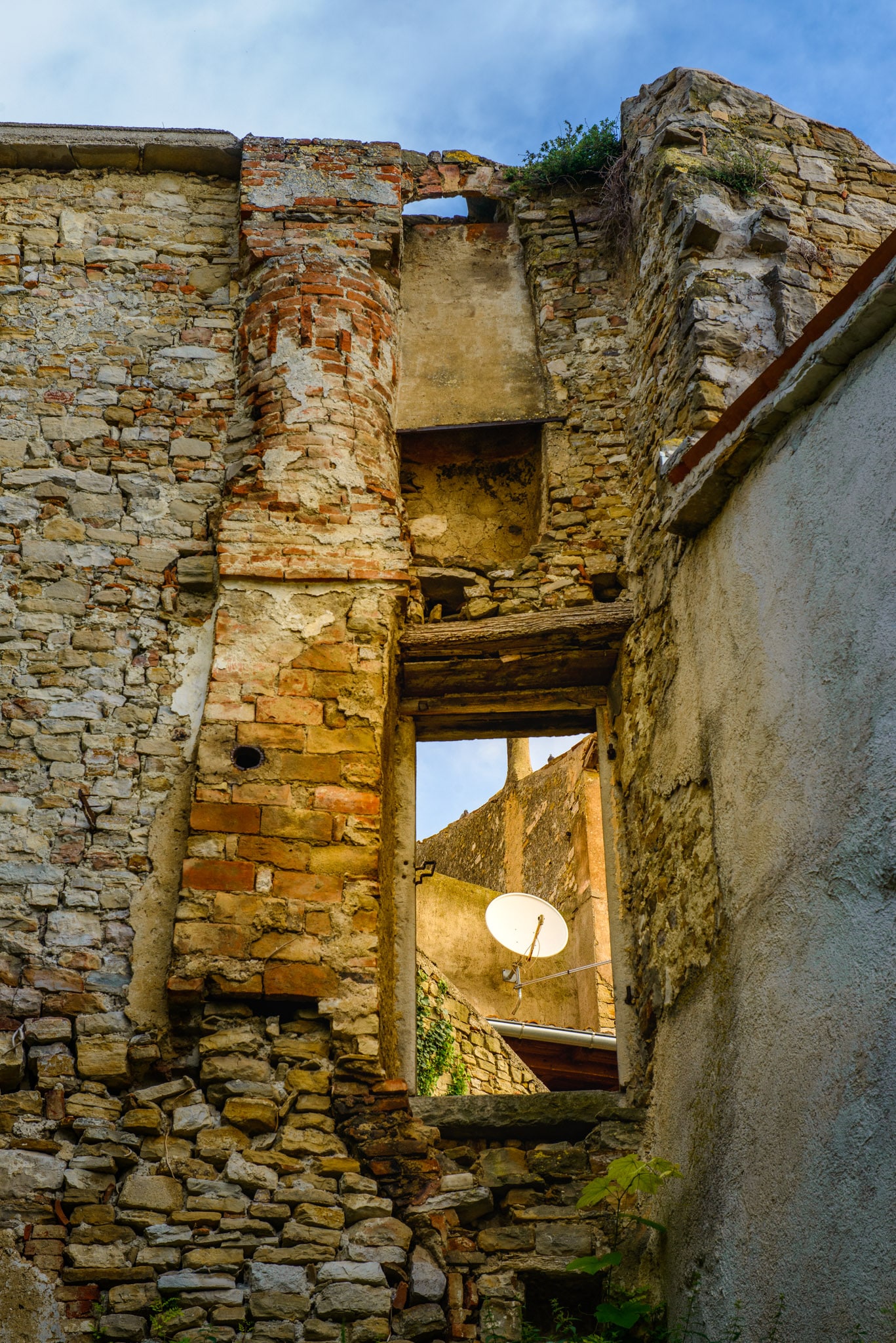 A satellite dish is visible through a window in some ruins in the Medieval Istrian village of Motovun in Croatia.