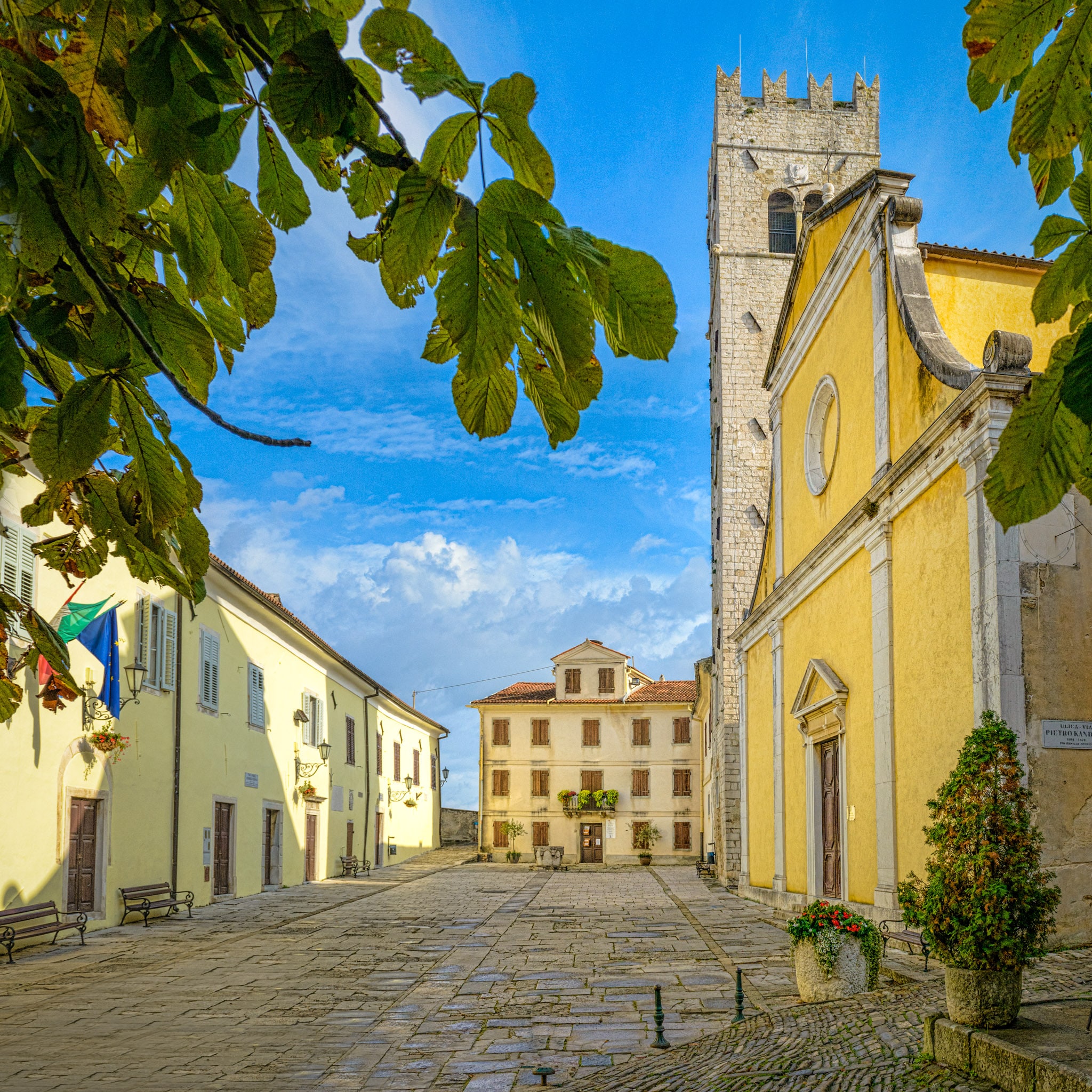 A view of the central square of the Medieval Istrian village of Motovun, Croatia, with the 13th Century bell tower, the Church of St. Stephen, and the Romanesque Municipal Palace.