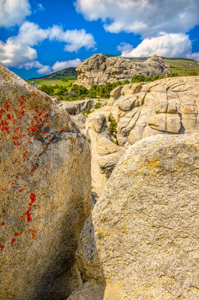 A view through a cleft in a granite rock showing additional granite formations in the distance in City of Rocks National Preserve, near Almo, Idaho.