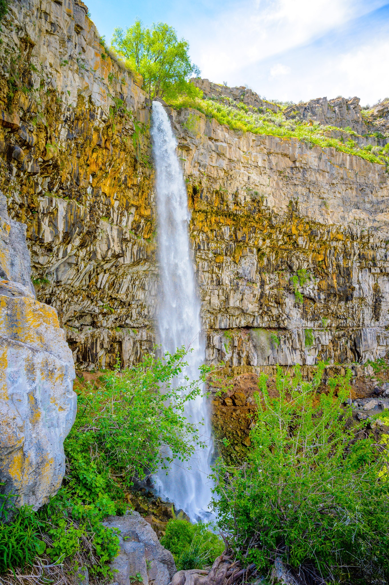 This view of Perrine Coulee Falls was taken from the road leading down to Centennial Waterfront Park in Twin Falls, Idaho. Perrine Coulee Falls is unique because its flow increases during the summer. This is due to overflow from irrigation canals farther upstream that gather in the valley, also called a coulee, and then flows downstream to the falls.