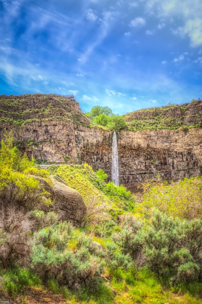 This view of Perrine Coulee Falls was taken from Centennial Waterfront Park in Twin Falls, Idaho. Perrine Coulee Falls is unique because its flow increases during the summer. This is due to overflow from irrigation canals farther upstream that gather in the valley, also called a coulee, and then flows downstream to the falls.