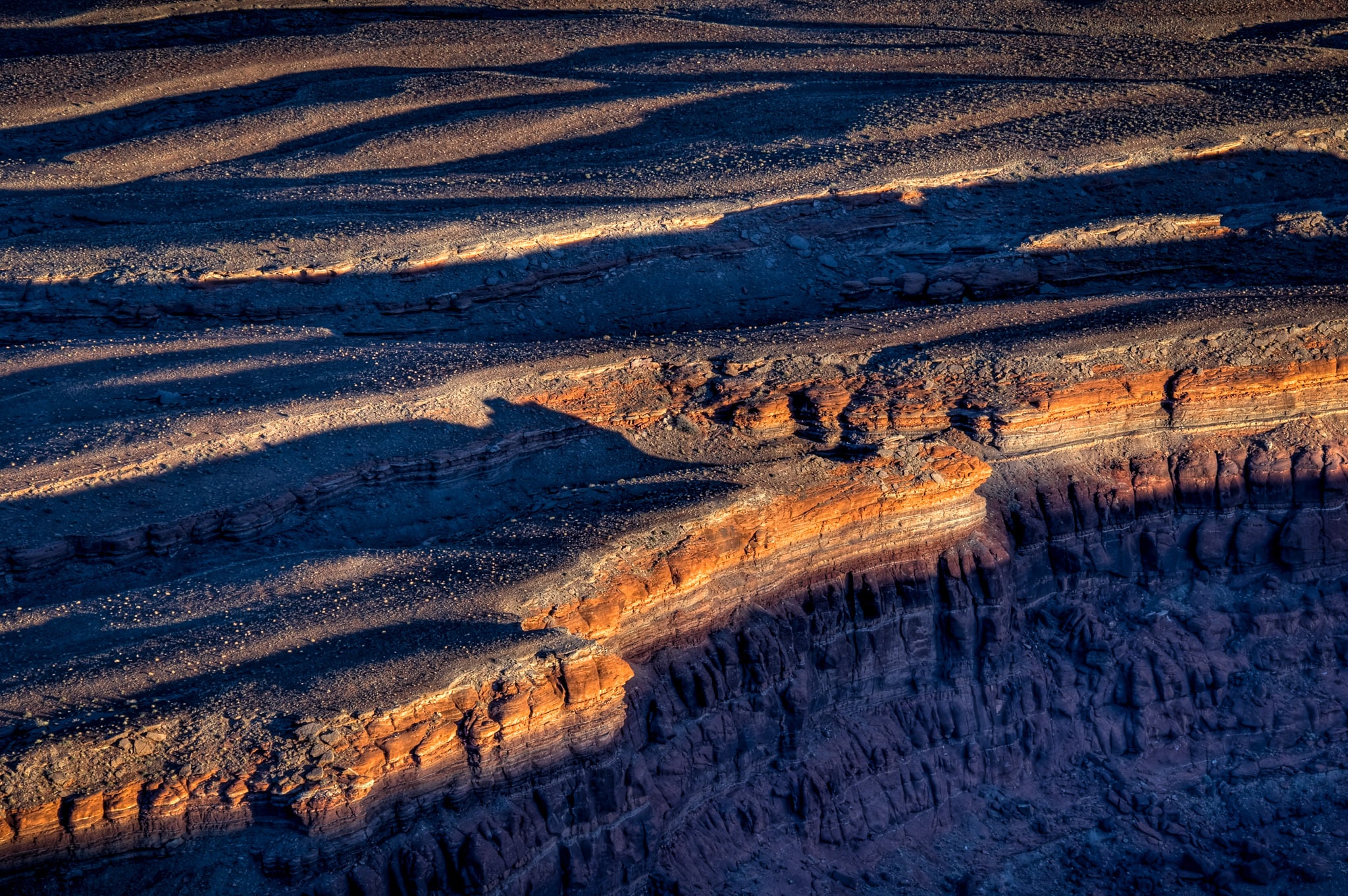 Sunset light catches the lip of the plateau below Dead Horse Point near Moab, Utah.