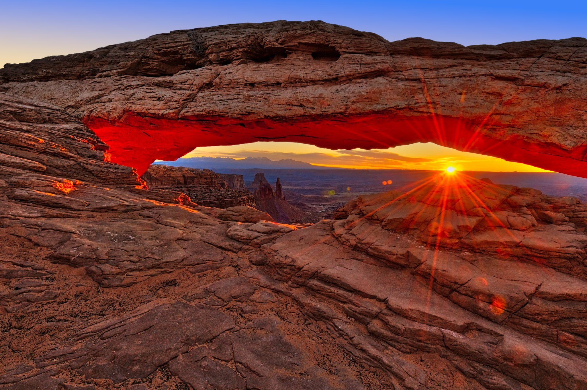 At dawn, looking east through Mesa Arch in Canyonlands National Park.