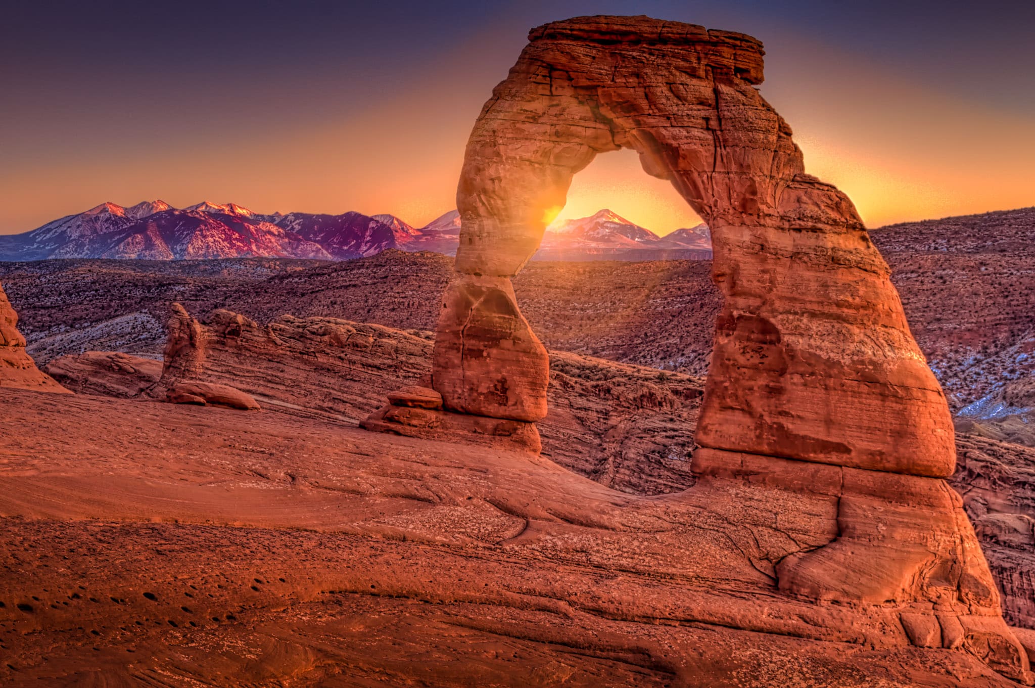 Dusk view of Delicate Arch with the last light of day playing on the La Sal Mountains.