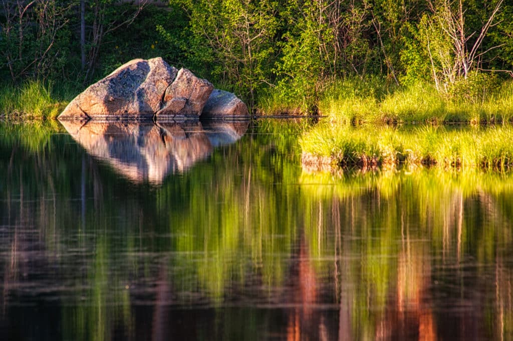 Zen rock reflected in Sprague Lake in Rocky Mountain Park.