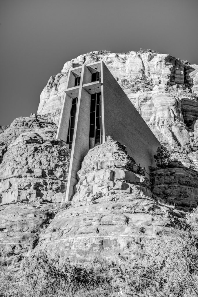A black and white exterior view of the Chapel of the Holy Cross in Sedona, Arizona.