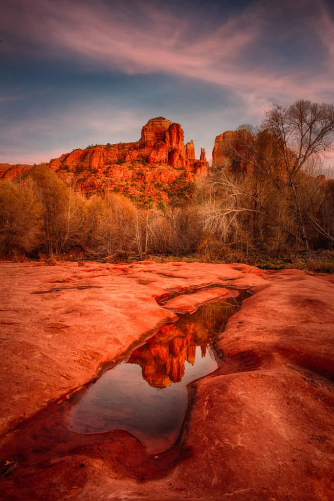The classic view of Cathedral Rock reflected in the pot holes in Red Rock Crossing, along Oak Creek in Sedona, Arizona.
