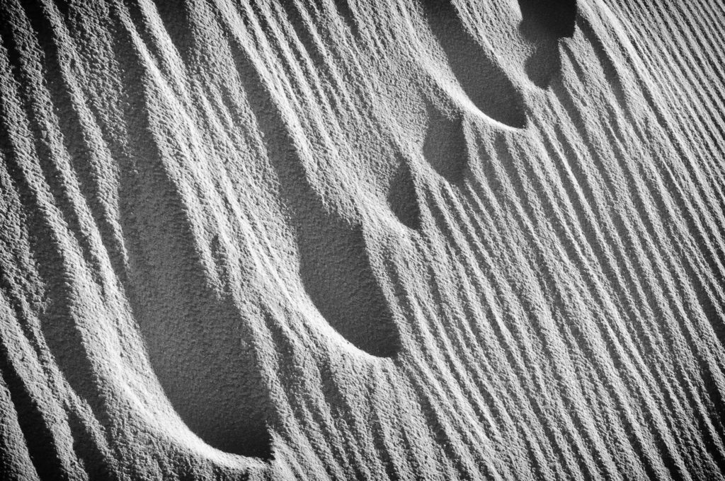 Eroded footprints ascending a dune in White Sands National Monument.