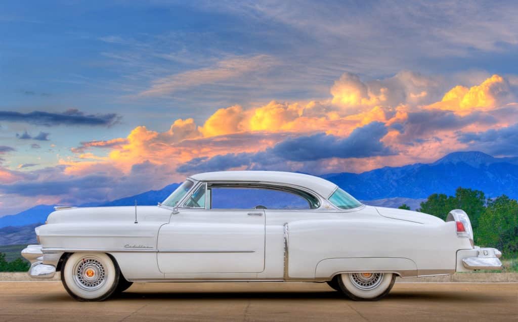 1953 Cadillac Coupe deVille - Side view, driver's side with sunset clouds in distance.