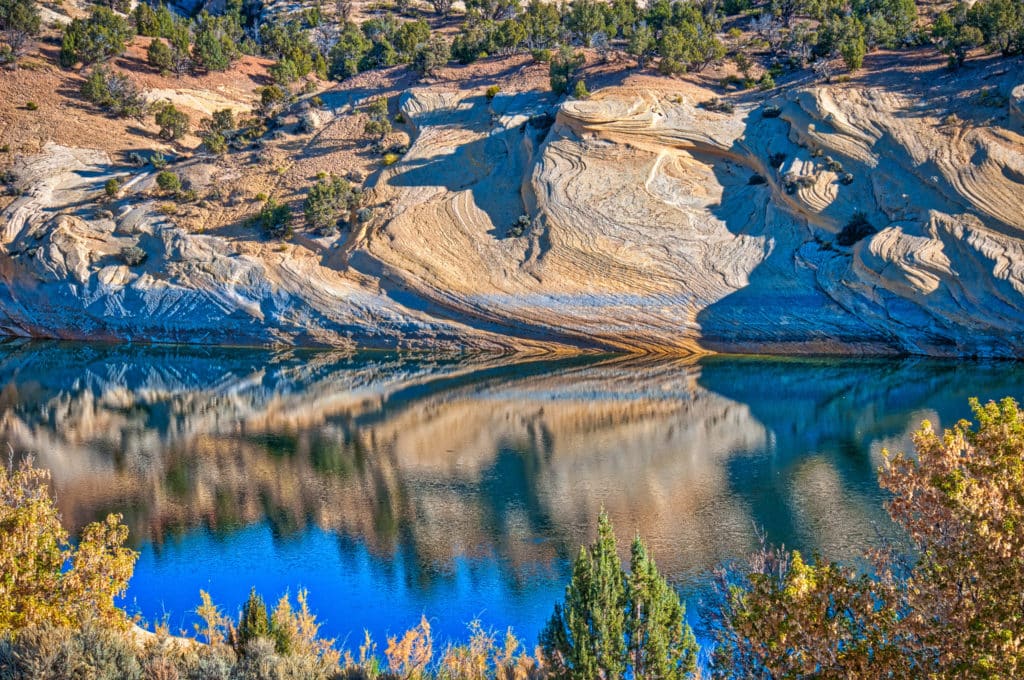 Petrified dunes of Weber Sandstone are reflected in Red Fleet reservoir on a fall day in Red Fleet State Park, north of Vernal, Utah.