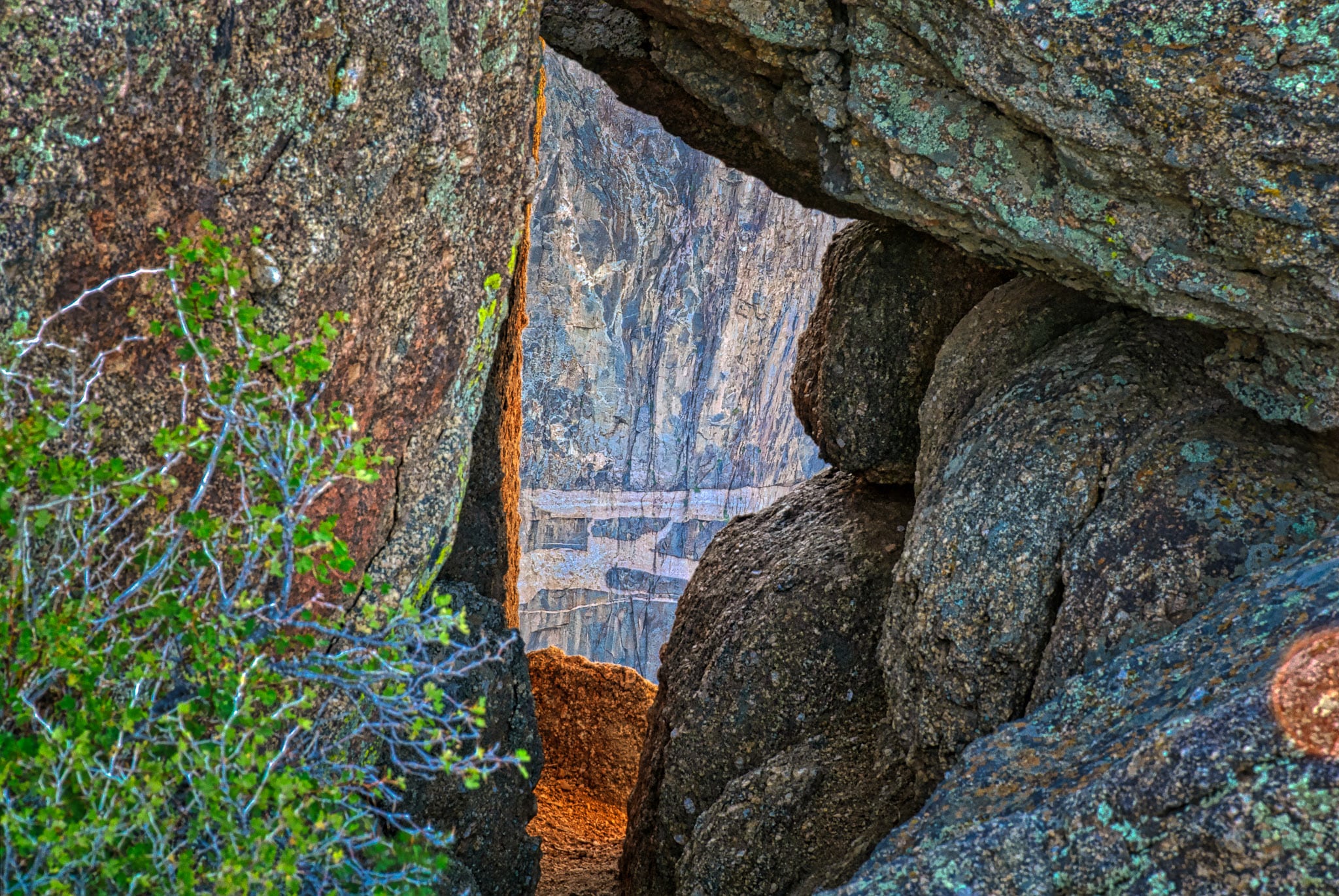 A view of the Painted Wall is nicely framed by boulders of ancient granite and schist. The scene is photographed from an overlook near the South Rim visitor's center in Black Canyon of the Gunnison National Park near Montrose, Colorado.