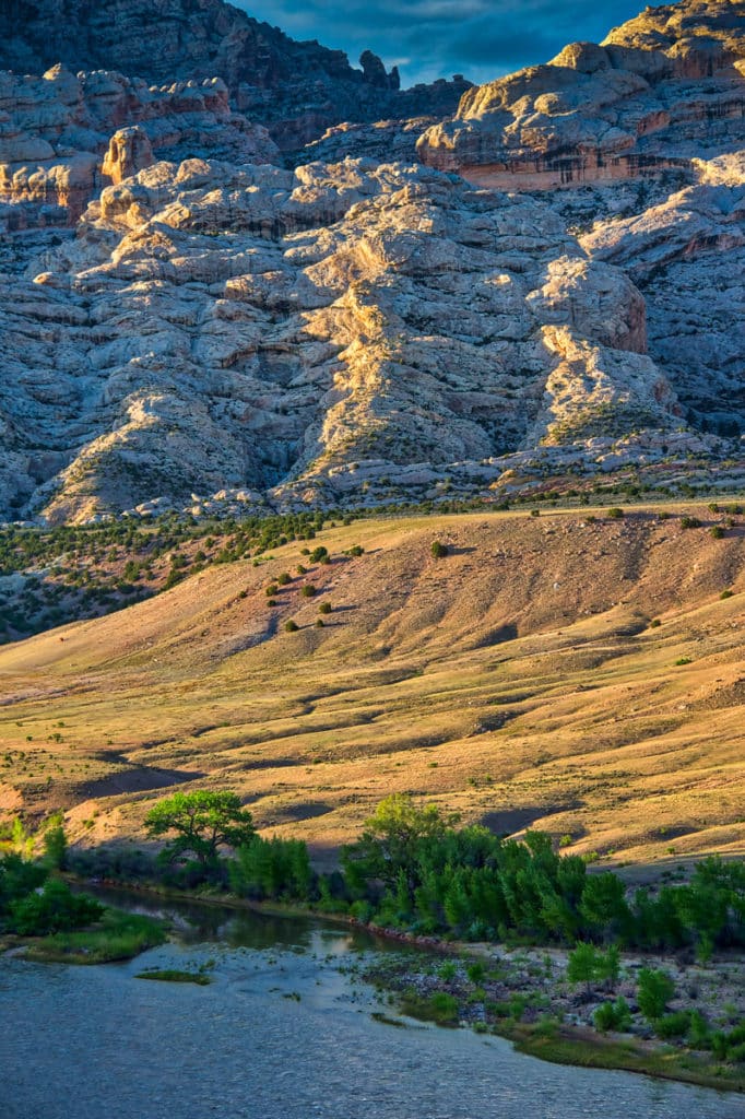 The Weber Sandstone of Split Mountain in Dinosaur National Monument catches the late afternoon sun. The Green River flows past in the foreground.