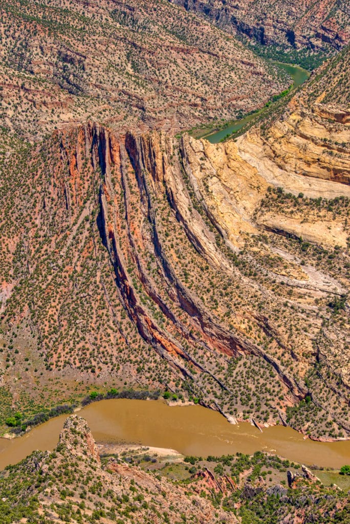 A portrait view of the Mitten Park Fault along the Green River ib Dinosaur National Monument, Colorado. It showcases the interbedded sandstone and limestone layers of the Morgan formations up against the Weber Sandstone.