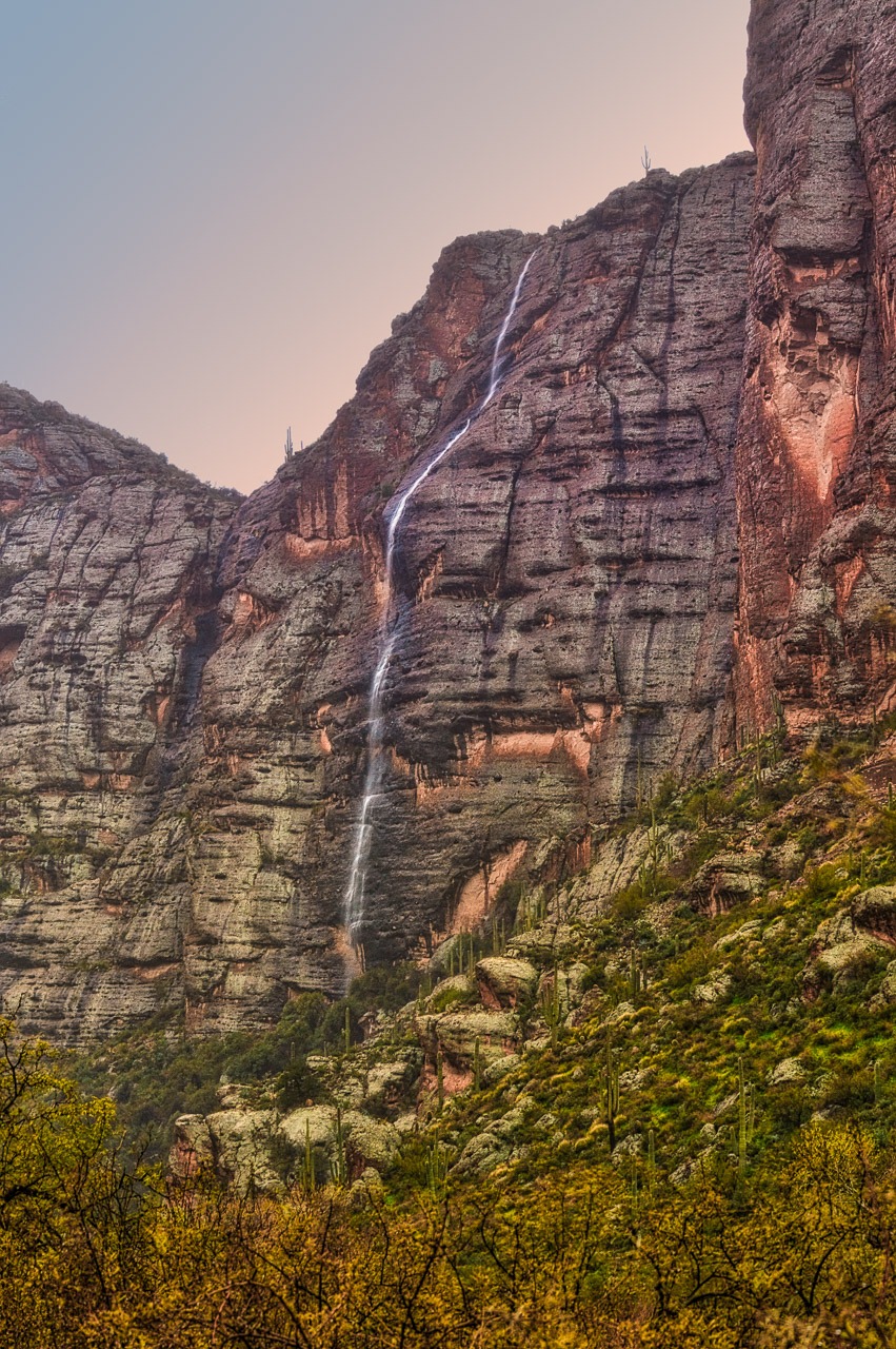 An intermittent waterfall caused by heavy rains cascades down the cliff face along the Apache Trail in Arizona.