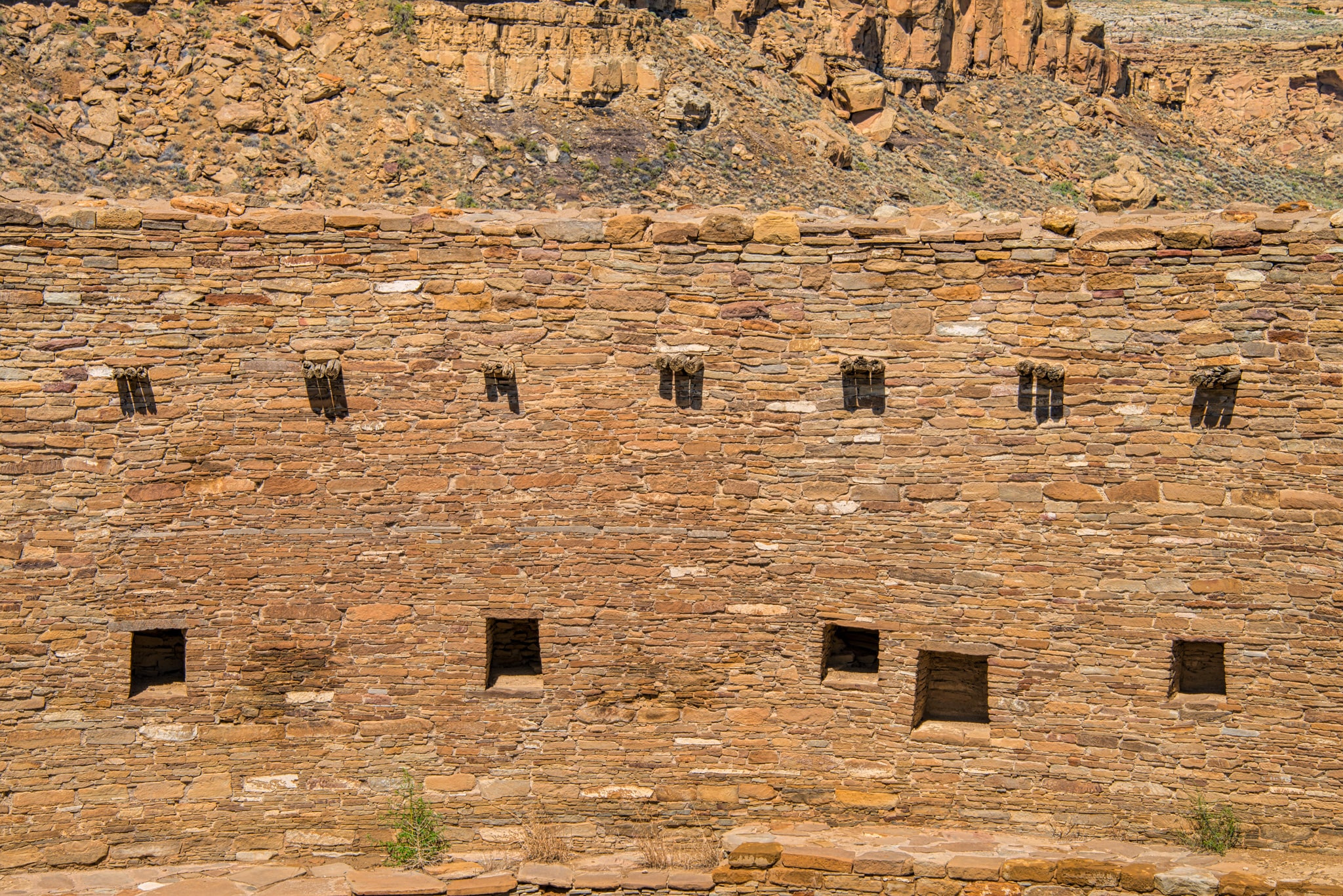 This is a detail of the south-facing interior wall of the Great Kiva at Casa Rinconada, across Chaco Wash from Pueblo Bonito in Chaco Canyon, New Mexico. Featured on the wall are vigas in groups of three and multiple niches. NCAR's High Altitude Observatory postulate that this slightly above-ground kiva was used for astromnomical observations and religeous ceremonies based on its orientation, location, and symmetry.