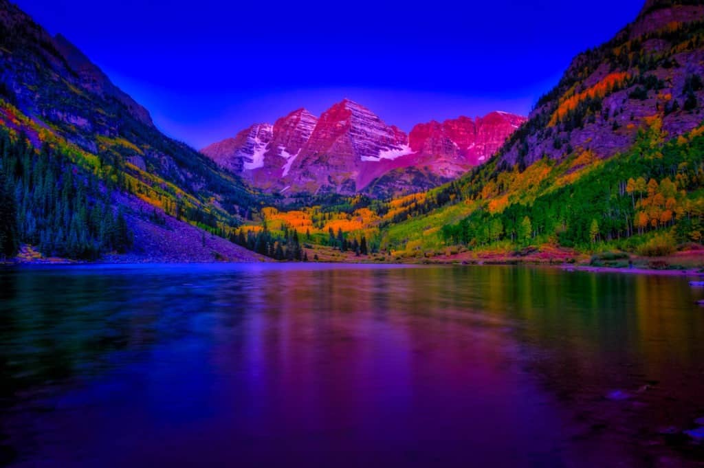 Magenta morning light kisses the Maroon Bells just before dawn in the Maroon Bells Recreation Area near Aspen, Colorado.