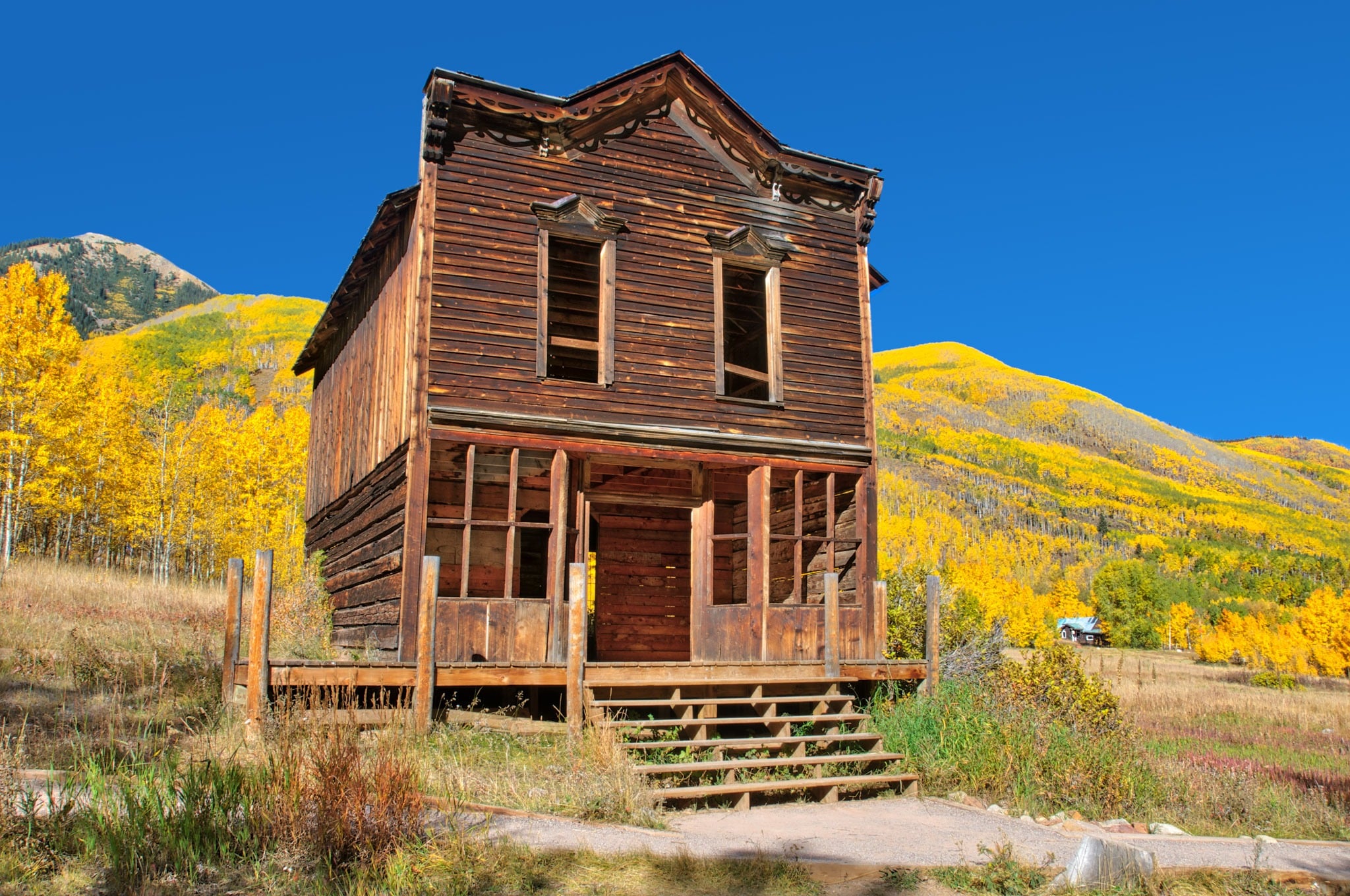 The remains of an old hotel with gingerbread along the roofline is on a street in Ashcroft Ghost Town near Aspen, Colorado.