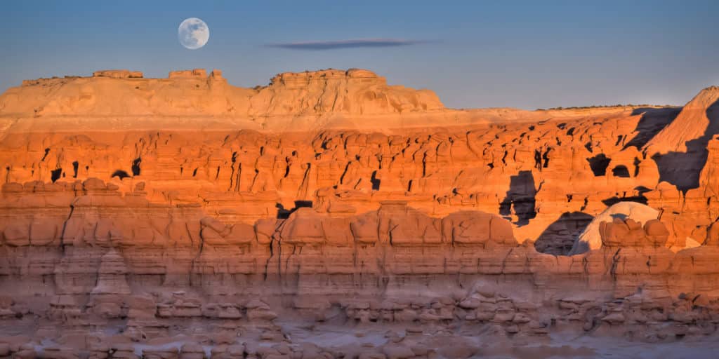 The full moon rises over Goblin Valley State Park at sunset.
