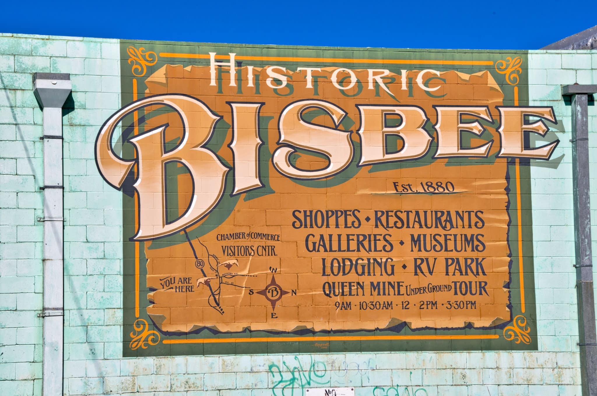 This sign painted on a building at the intersection of Tombstone Canyon Road, Commerce Street, and Main Street welcomes visitors to Bisbee, Arizona.
