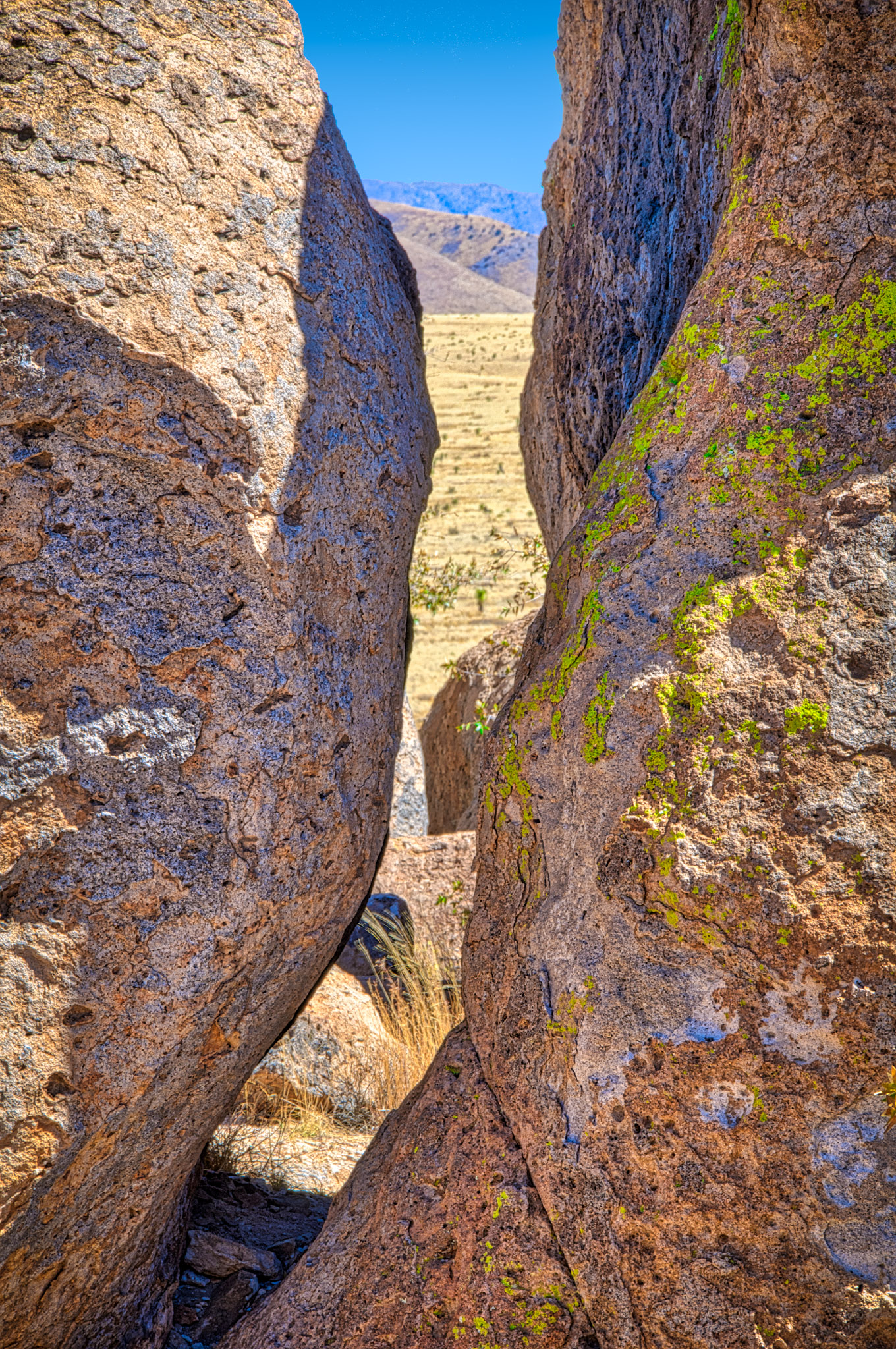 This slit in the rocks provides a view out across the pain to the mountains in the distance. Taken in City of Rocks State Park in southern New Mexico.