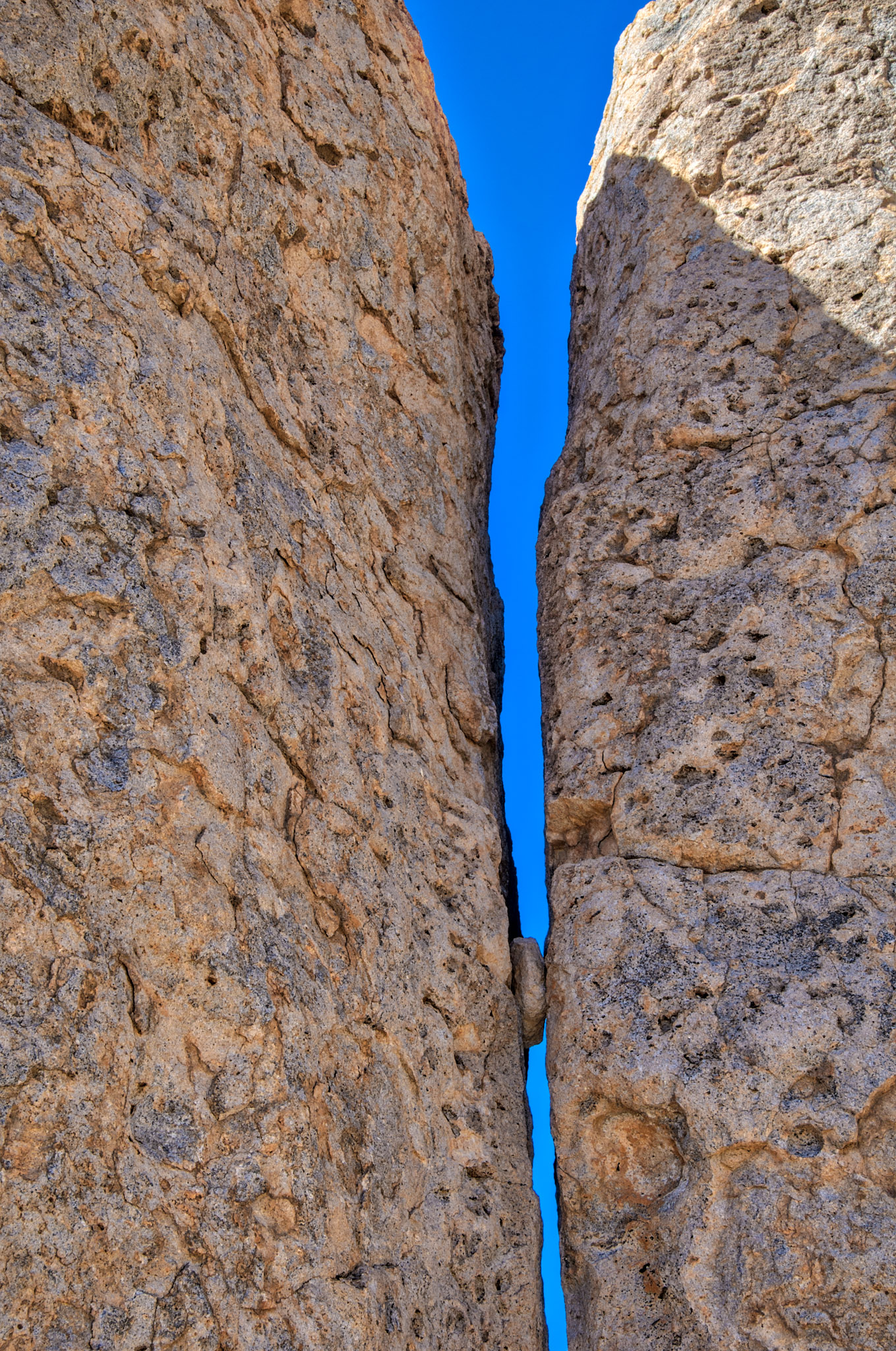 A piece of eroded rock is trapped in a crack between two pinnacles in City of Rocks State Park between Deming and Silver City, New Mexico.