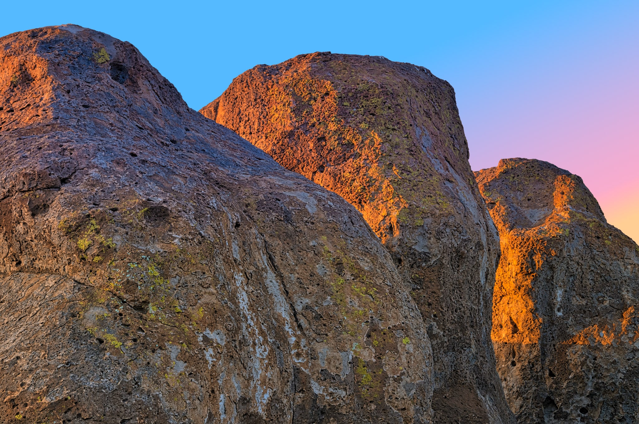 Alpenglow tinges the sky blue, pink, and yellow at sunset in City of Rocks State Park near Silver City, New Mexico.