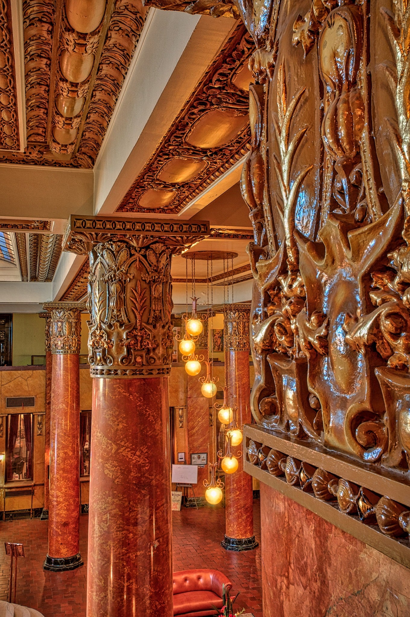 A view of the grand Hotel Gadsden lobby highlighting the leather furniture, tile floors, Italian marble, stained glass, and expansive grand staircase. Notice the spiral central chandelier.