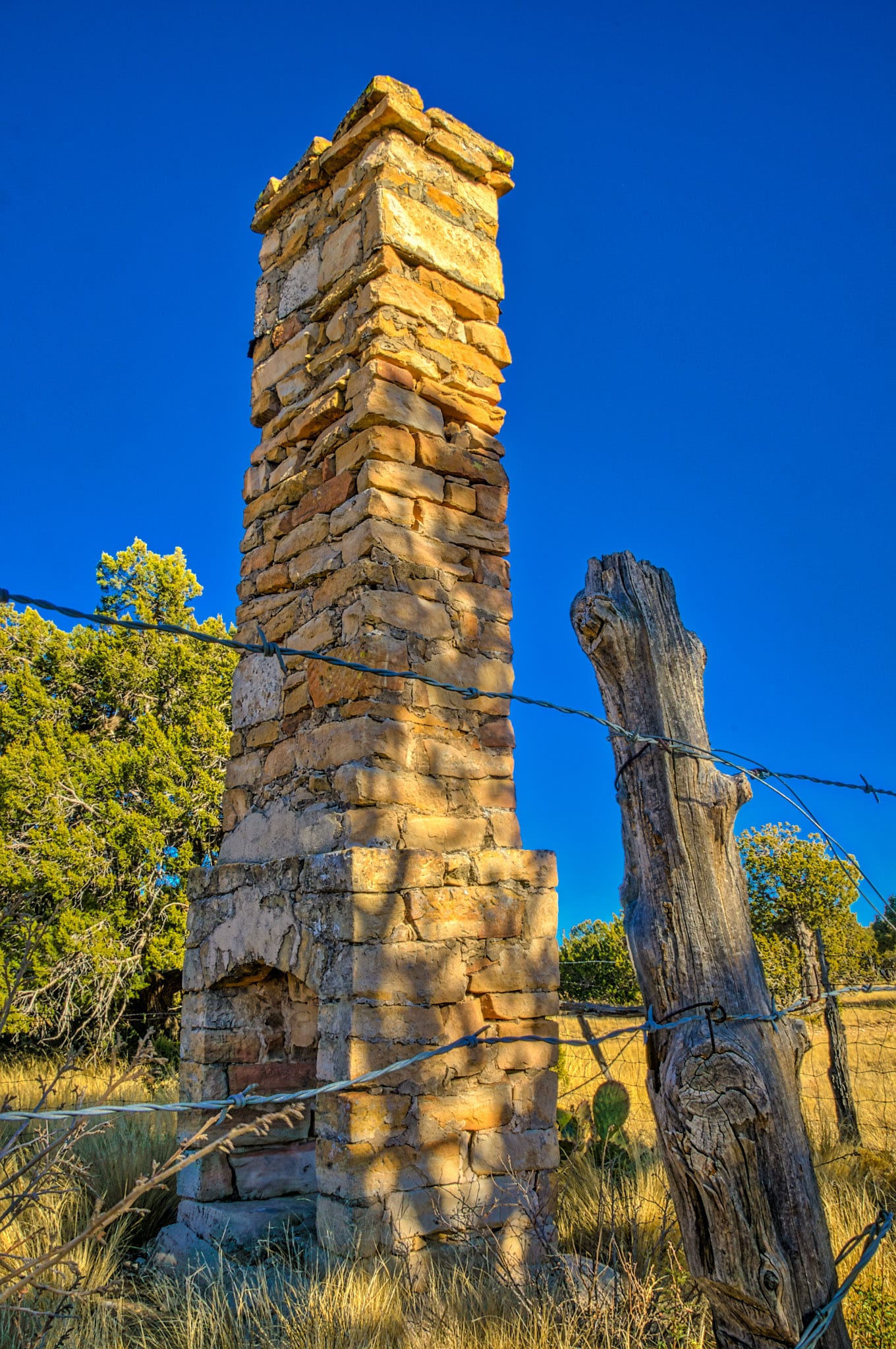 The remnants of a fireplace can be seen along the road near Queen, along County Road 137 in the Lincoln National Forest close to Carlsbad, New Mexico.