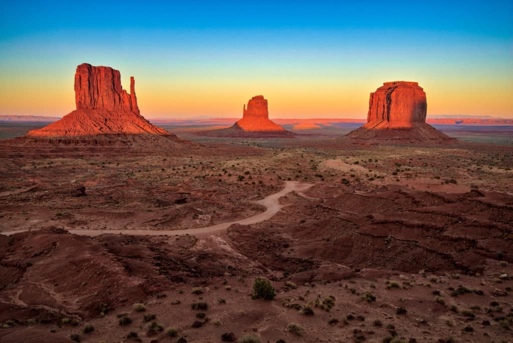 Sunset at Monument Valley Navajo Tribal Park taken from near the visitor's center. West Mitten, East Mitten and Merrick Butte are pictured.
