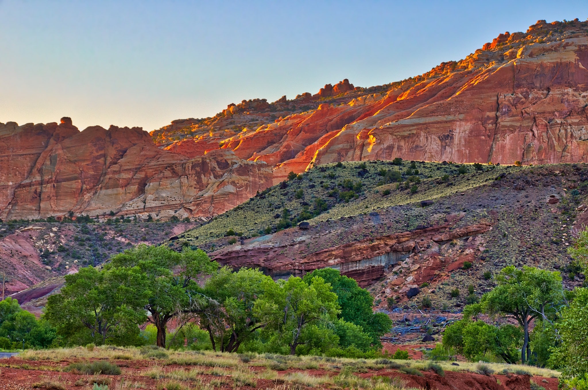 The first light catches the edges of cliffs above Sulphur creek just upstream of its junction with the Fremont River in Capitol Reef National Park Utah.