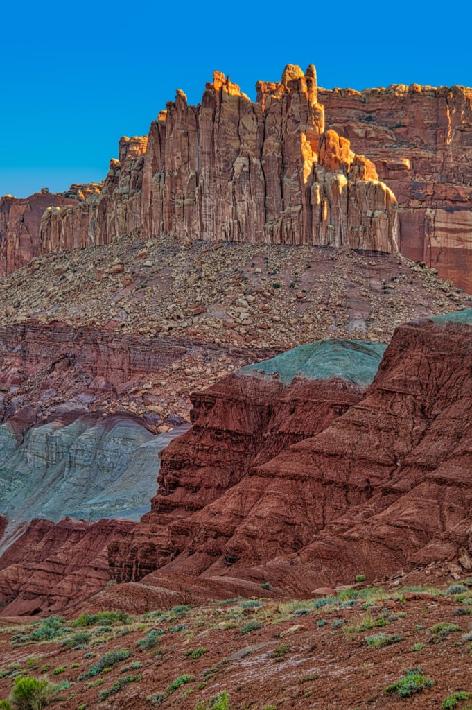 Along Utah Highway 24 near the Capitol Reef National Park Visitor Center, you can see layers of vari-colored rock formations, including the Chinle Formation, in a feature called The Castle.