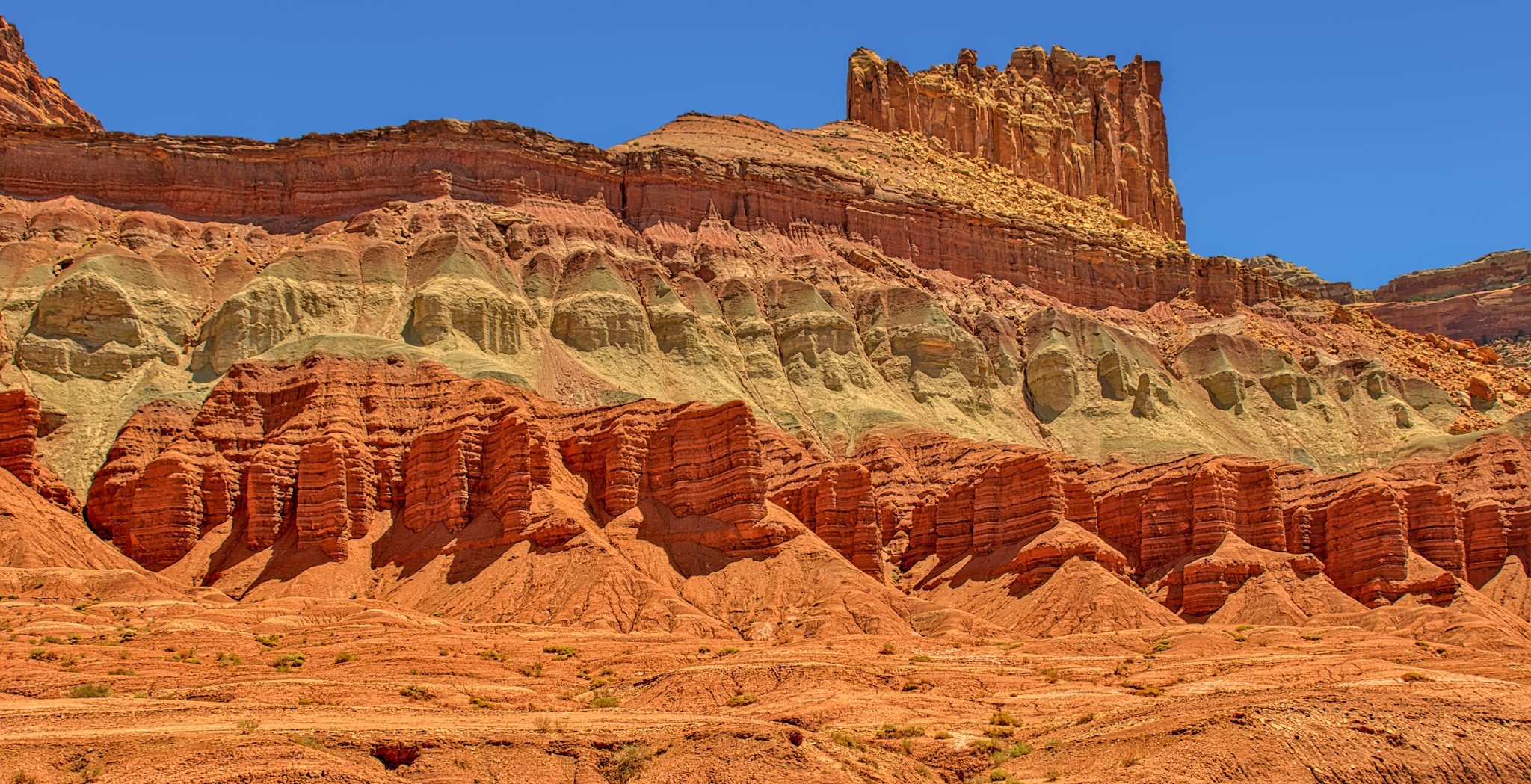 This is a view of the stratified rock formations along Utah State Route 24 in Capitol Reef National Park. From this vantage point, you can see the Moenkopi, Chinle, and Wingate Formations.