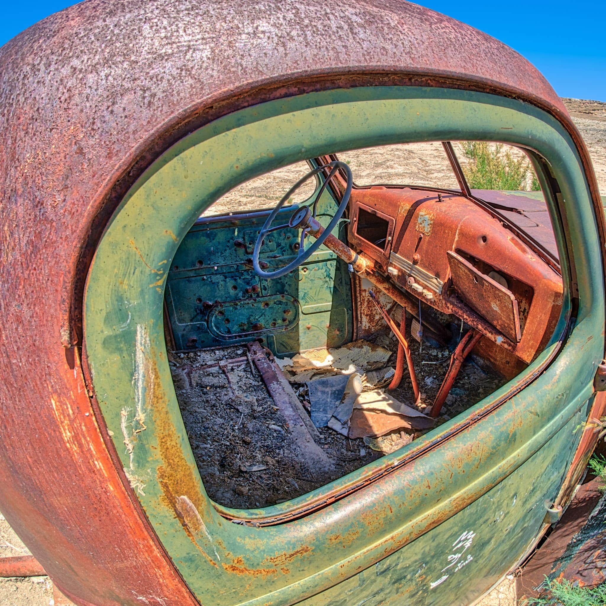 Bullet riddled cab of a water-drilling rig abandoned along Hartnet Road on the way to Cathedral Valley in Capitol Reef National Park, Utah.