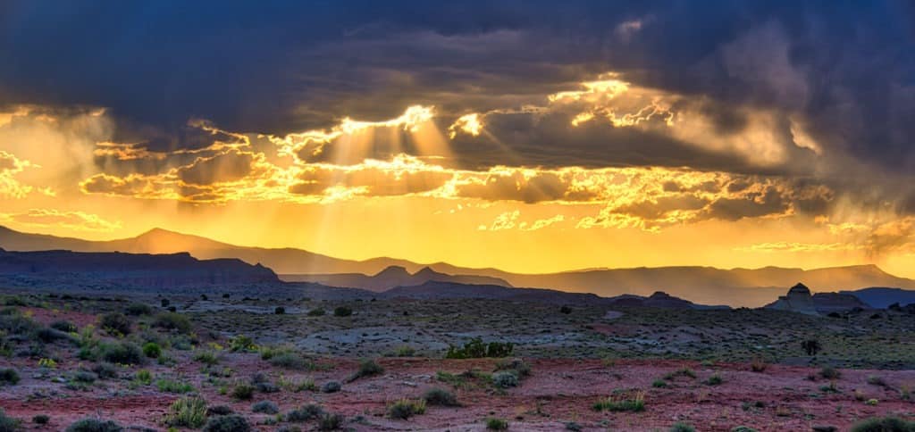 The sun's rays break through clouds along Cathedral Road in Capitol Reef National Park, Utah.